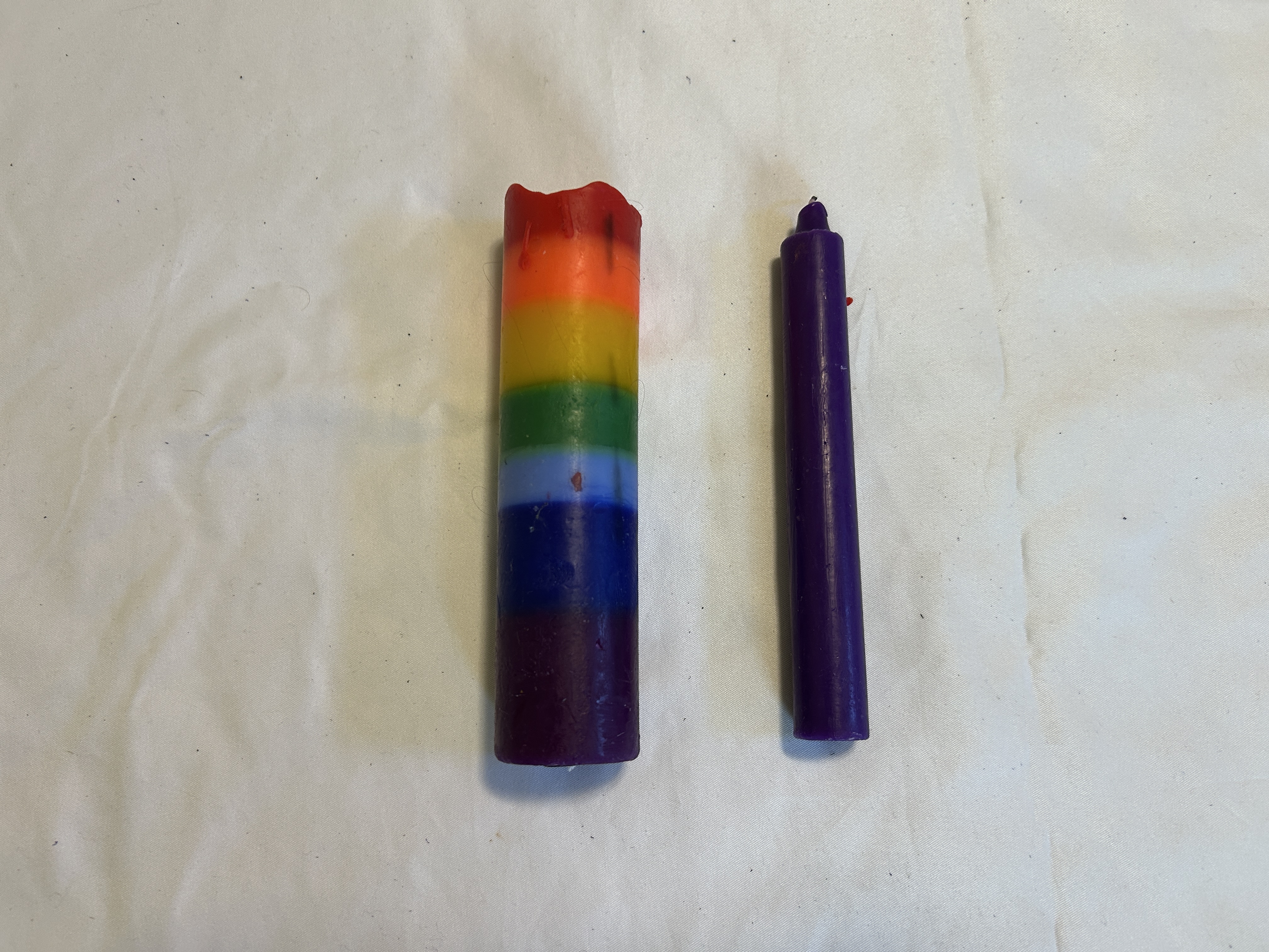 Body-safe candles resting on a white sheet